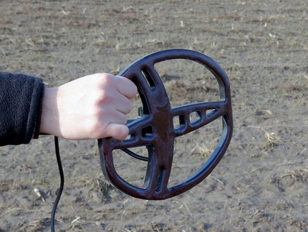 Part of metal detector in hand in fieldの写真素材