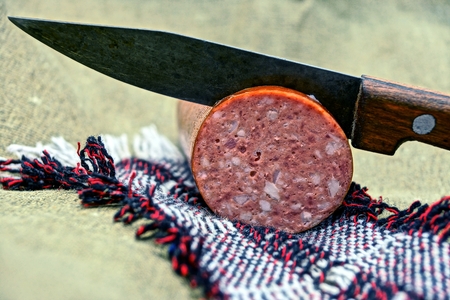 Piece of sausage cut with a knifeの写真素材