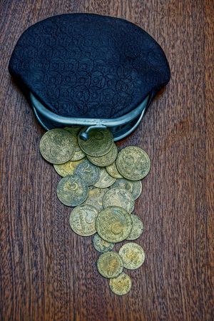 old wallet and coins on a brown tableの写真素材