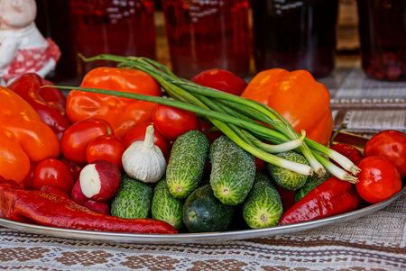Fresh vegetables on a large plate on a table covered with a tableclothの写真素材