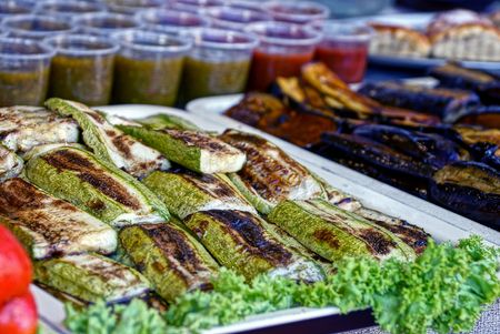 Fried zucchini and eggplants on a tray in glasses with sauceの写真素材