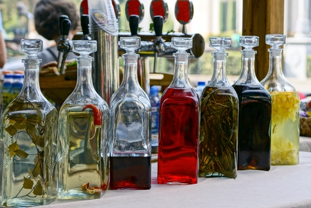 closed glass bottles with colored drinks on the table