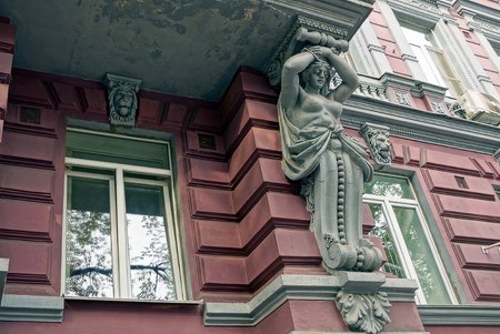 Part of an old balcony with a sculpture of a woman and the windows on the wallの写真素材