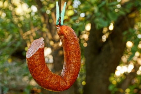 A piece of smoked sausage hangs on the yard