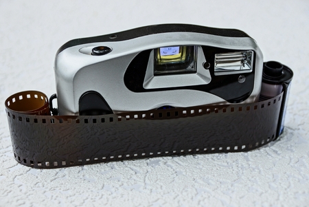 Old camera with a film on a gray surface