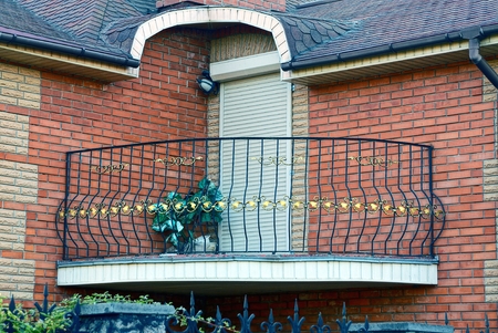 Iron open balcony with a door on the brick wall of the houseのeditorial素材