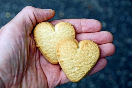 two dry cookies in the form of hearts on the palm