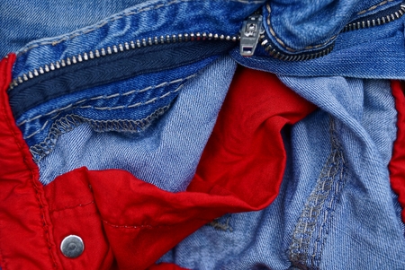 part of blue trousers with red pockets and an iron lockの写真素材