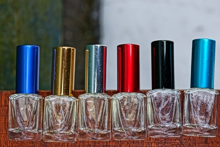 a row of beautiful glass bottles with colored lids for perfumeの写真素材
