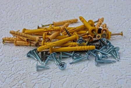 a set of dowels and screws of different colors on a gray backgroundの写真素材