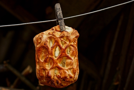 Fried patty with cottage cheese on a clothespin hanging on a wireの写真素材
