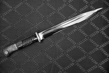 long old bayonet knife on gray cloth