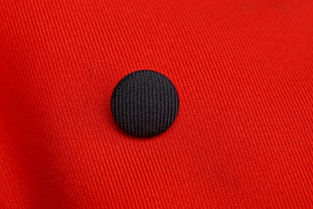 texture of a red fabric with a black round button
