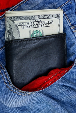 black leather wallet in the pocket of blue trousersの写真素材