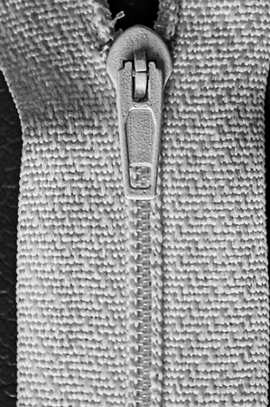 part of a zipper with a lock on a white clothの写真素材
