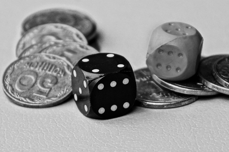 dice on a pile of coins on a table