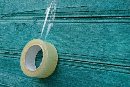transparent scotch hanging on a green wooden wall