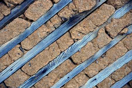 texture of wooden planks and dry clay on the wall