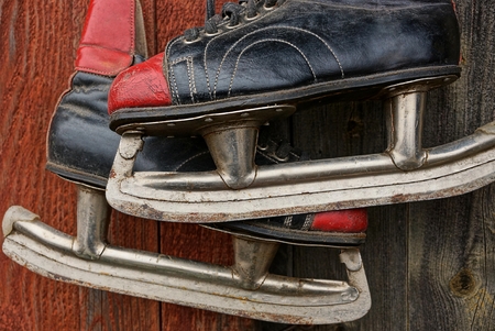 old colored skates hang on a wooden wallの写真素材