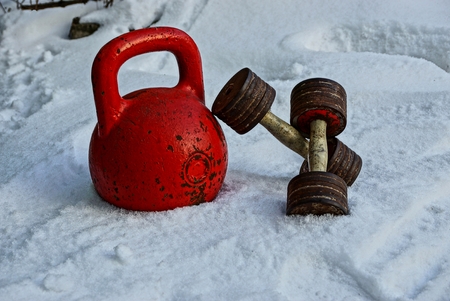 old weights and dumbbells in the street in the snowの写真素材