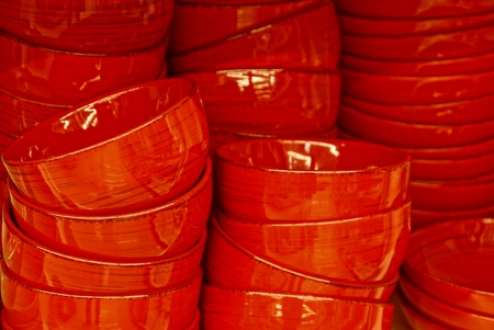 red clean dishes in a pile on a tableの写真素材