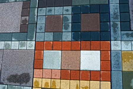 colored texture of stone square wet tiles on the sidewalk