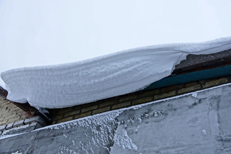 white snow drift on the roof of the houseの写真素材