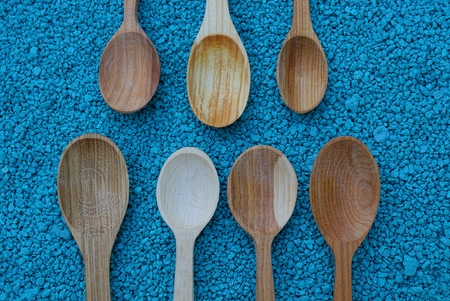 Wooden spoons in shallow blue stone sandの写真素材