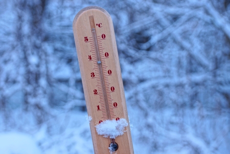 wooden thermometer in white snow on the streetの写真素材
