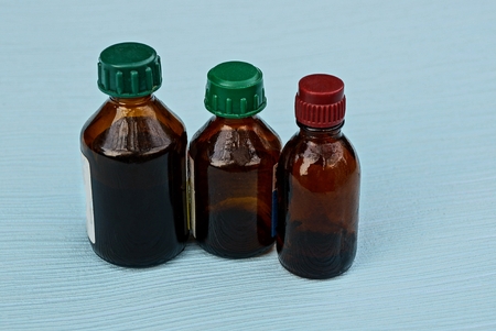 three small glass bottles on a blue tableの写真素材