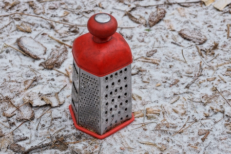 A red-gray big grater stands on the ground in the snowの写真素材
