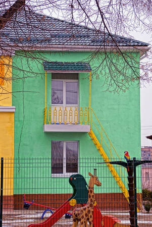 The building with a green wall and a playground in the yardの写真素材