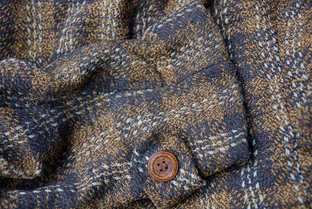 brown texture of a piece of clothing with a button on the sleeve