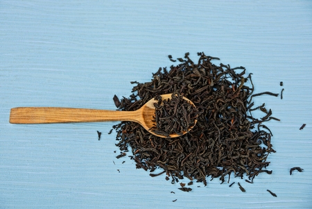 wooden spoon with tea on blue table in heapの写真素材