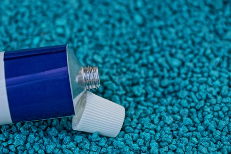 piece of iron tube with cream and lid on a blue backgroundの写真素材