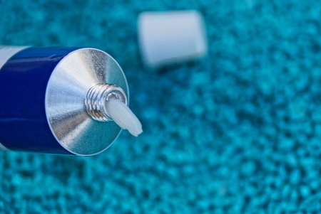 open tube with white cream on blue background