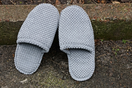 two wool gray slippers stand at the curb on the asphaltの写真素材