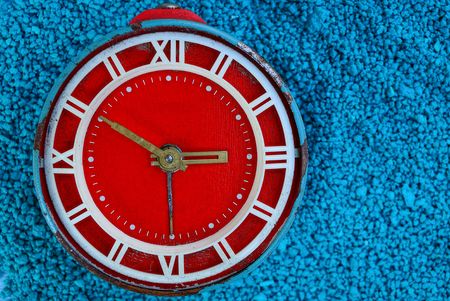 big red old alarm clock on blue backgroundの写真素材