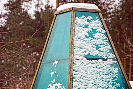 part of a glass green hothouse in the snow
