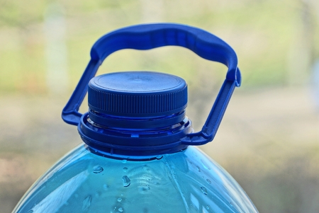 part of a plastic bottle with a blue stopperの写真素材