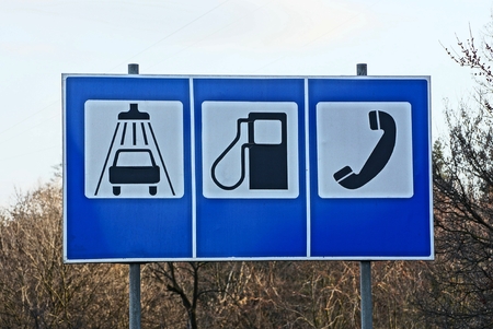 three large road signs with information about the service on the street near the roadの写真素材