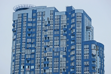 part of a large blue-gray house with balconies and windows against the skyの写真素材