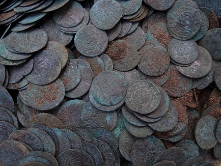 texture of a pile of old coins in the groundの写真素材