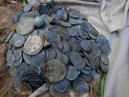 a pile of old and dirty silver coins in the ground on the streetの写真素材