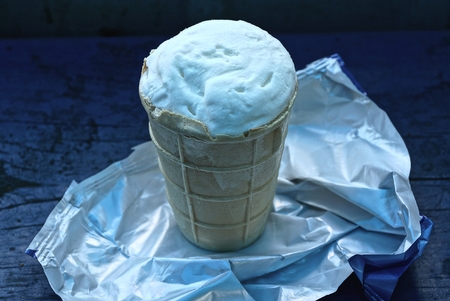white ice cream in a waffle cup on a table in a package