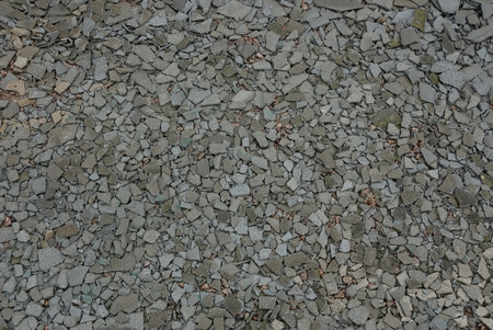 Gray stone texture of small stones and slices of slate on the road