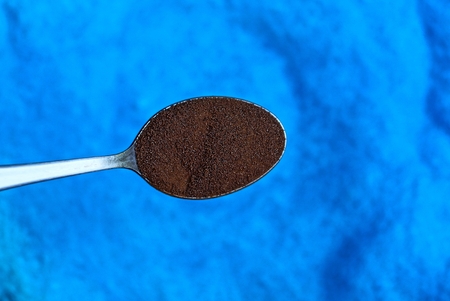 brown coffee spoon on a blue backgroundの写真素材