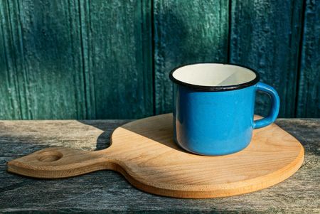 one big blue iron mug stands on a wooden tableの写真素材