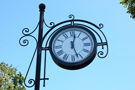 big round clock on a black skyの写真素材