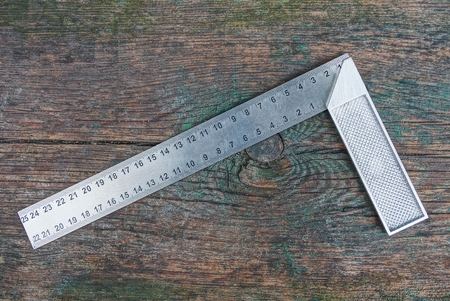 gray metal square tool lies on a wooden boardの写真素材